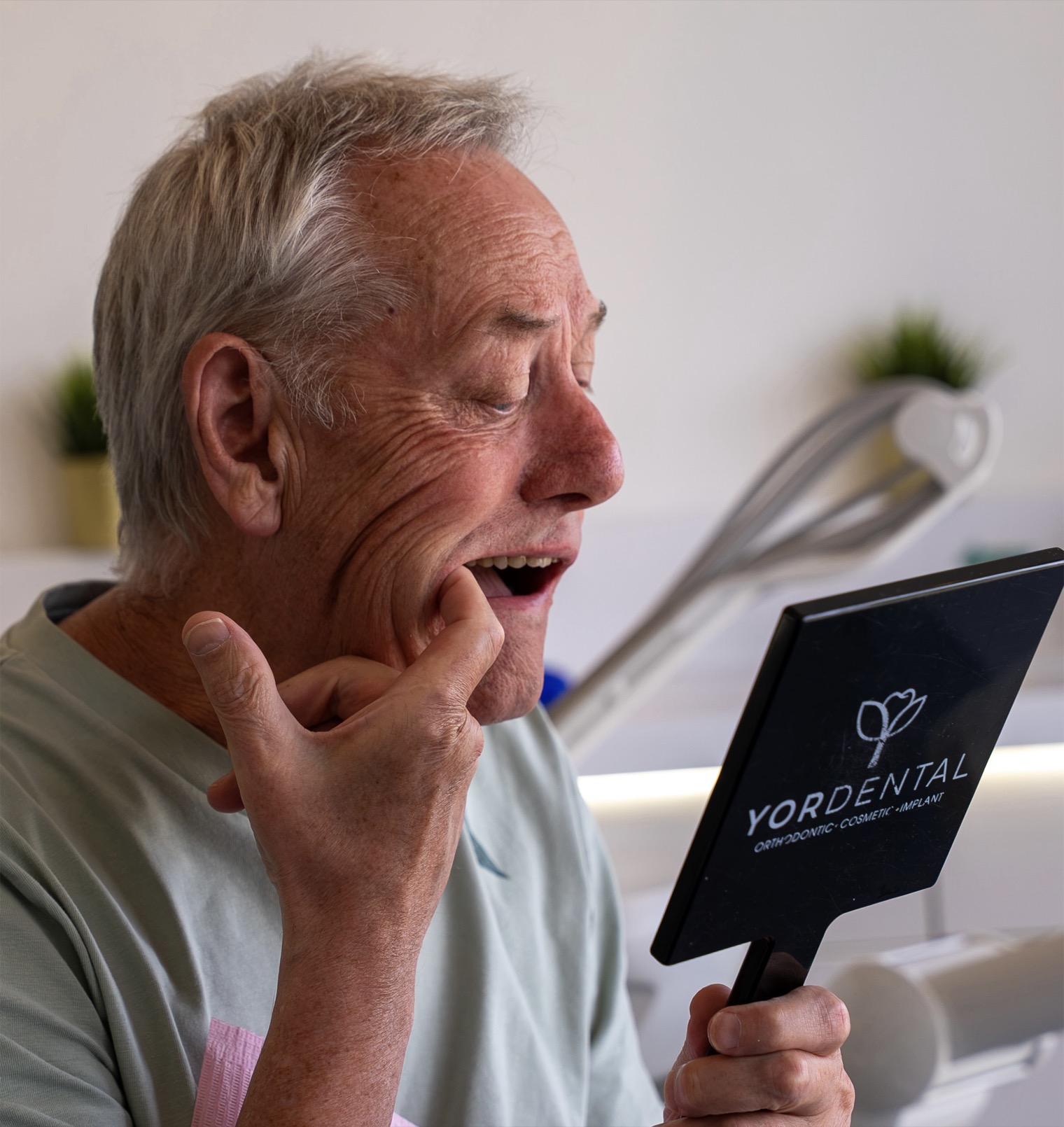 Man inspecting his teeth in a YOR Dental mirror