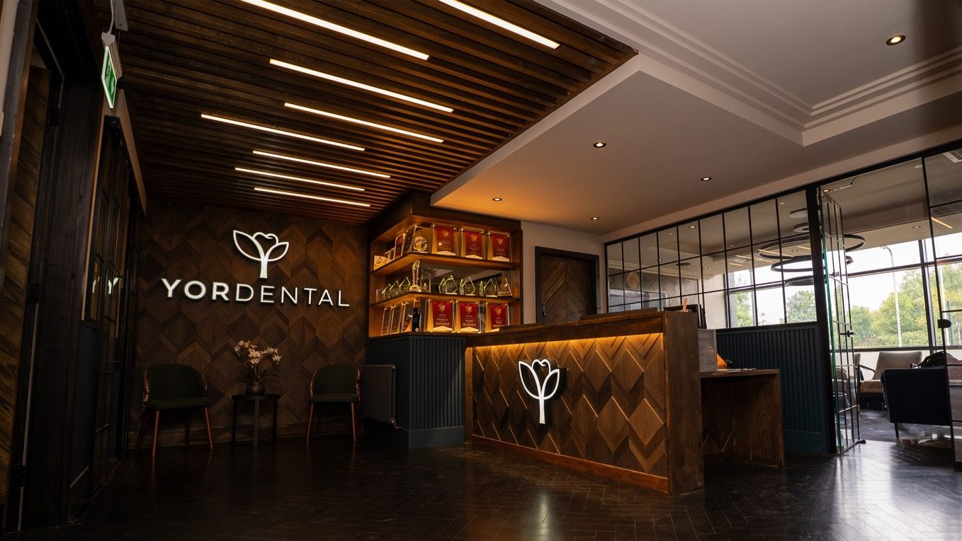 YOE Dental reception with the logo on the wall and the desk