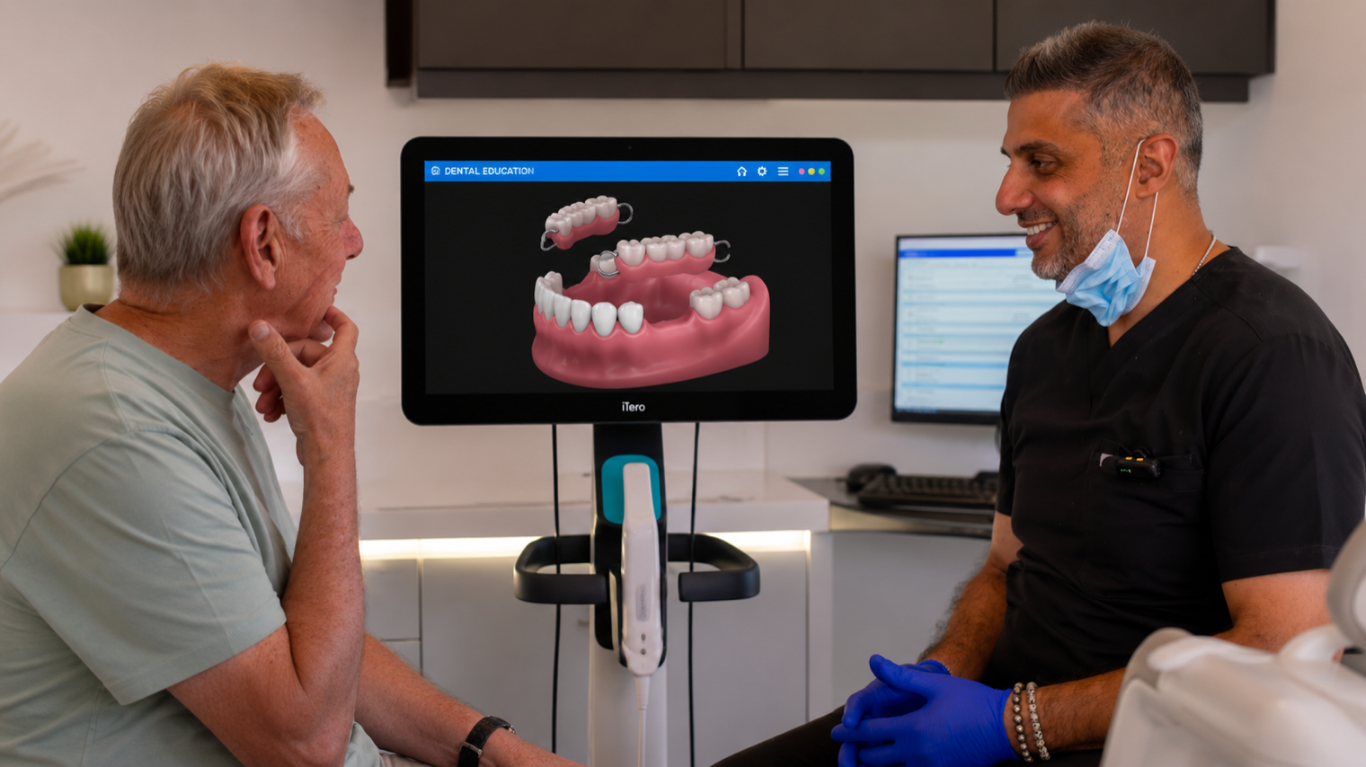a dentist and a man looking at a 3d rendering of dental implants