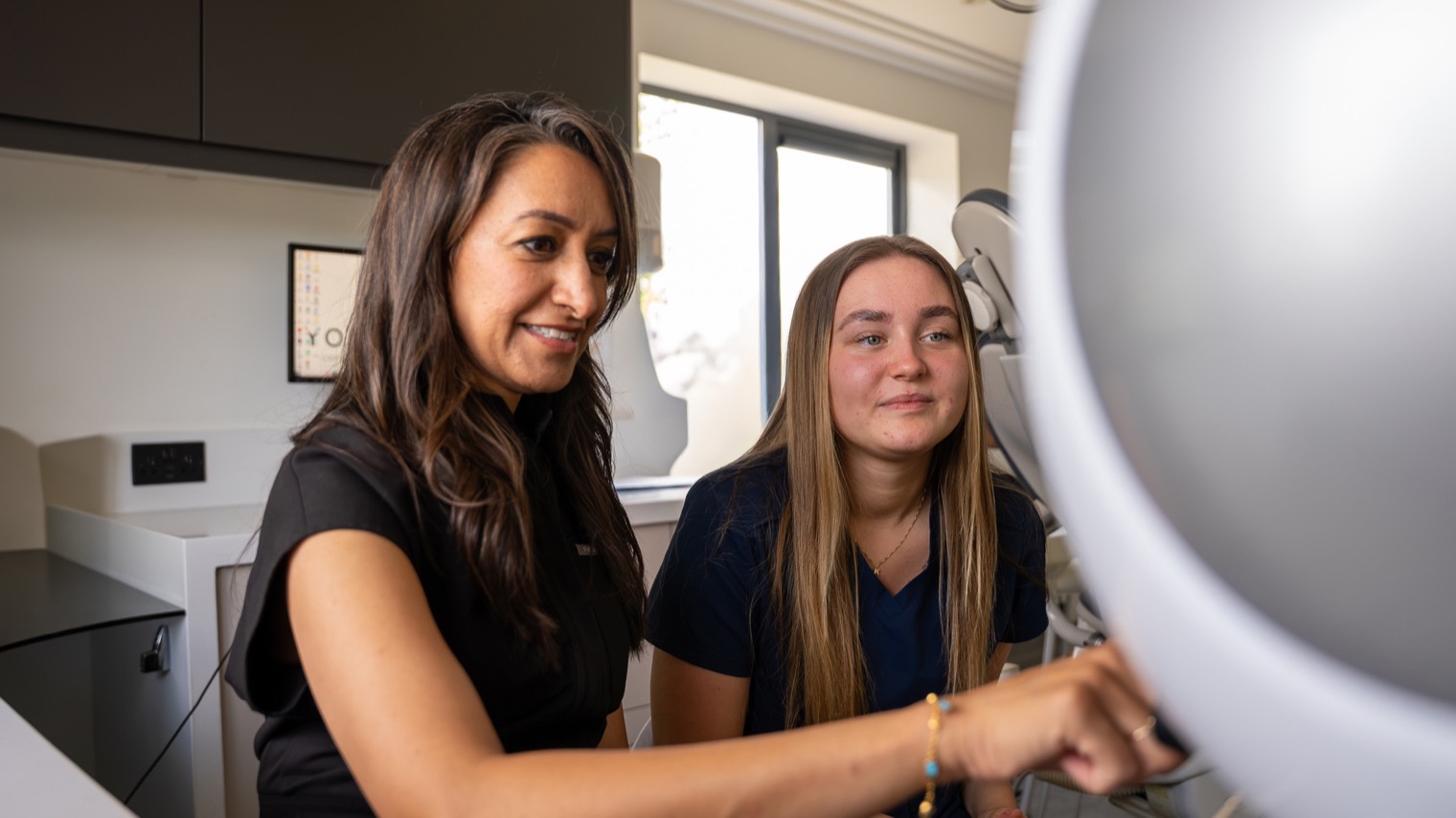 Deepa Vakil and a woman working in a dental office