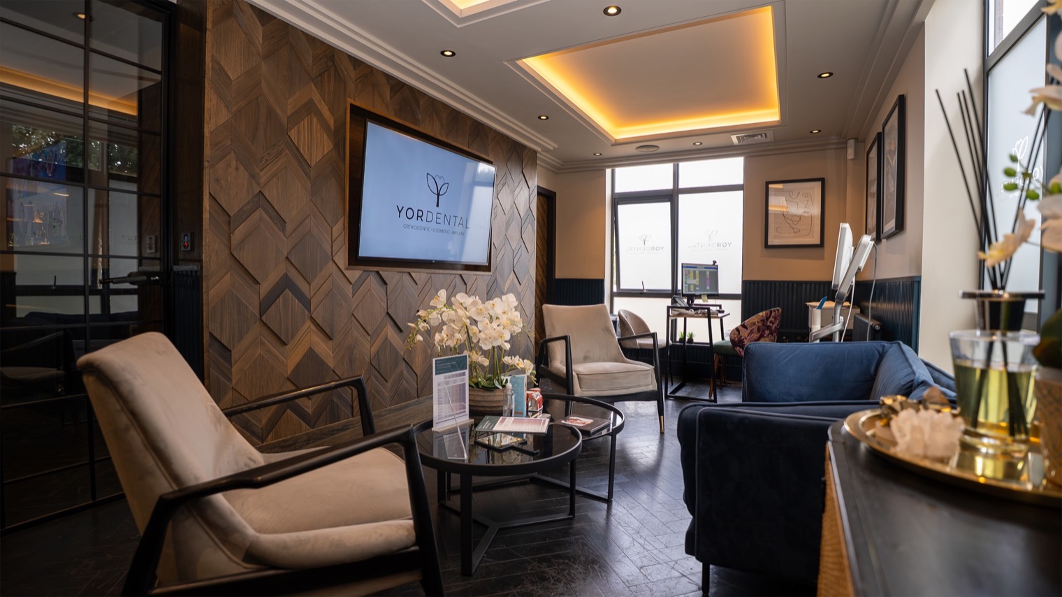 Picture of a YOR Dental waiting area with the logo on the television screen