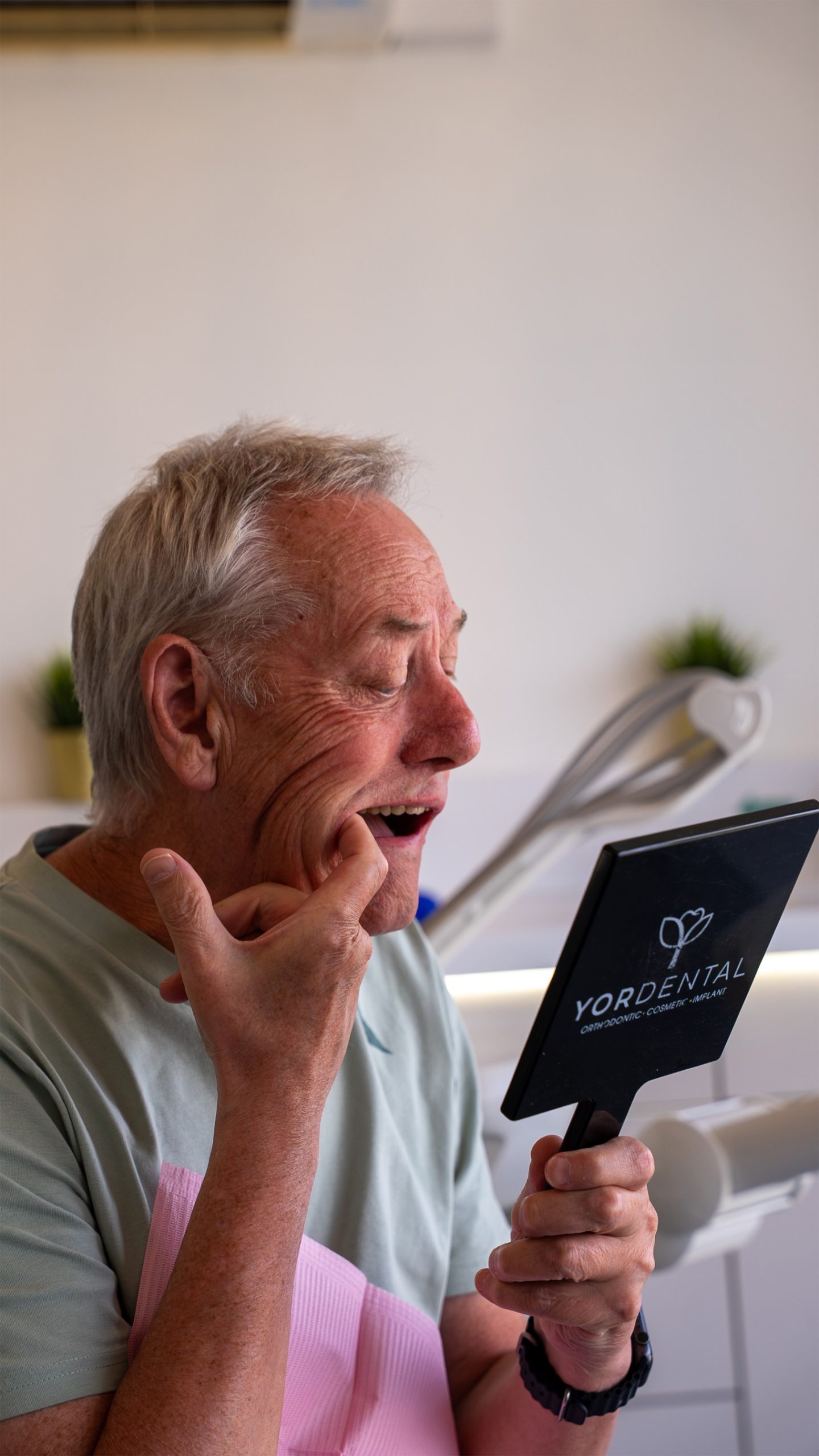 Man inspecting his teeth in a YOR Dental mirror